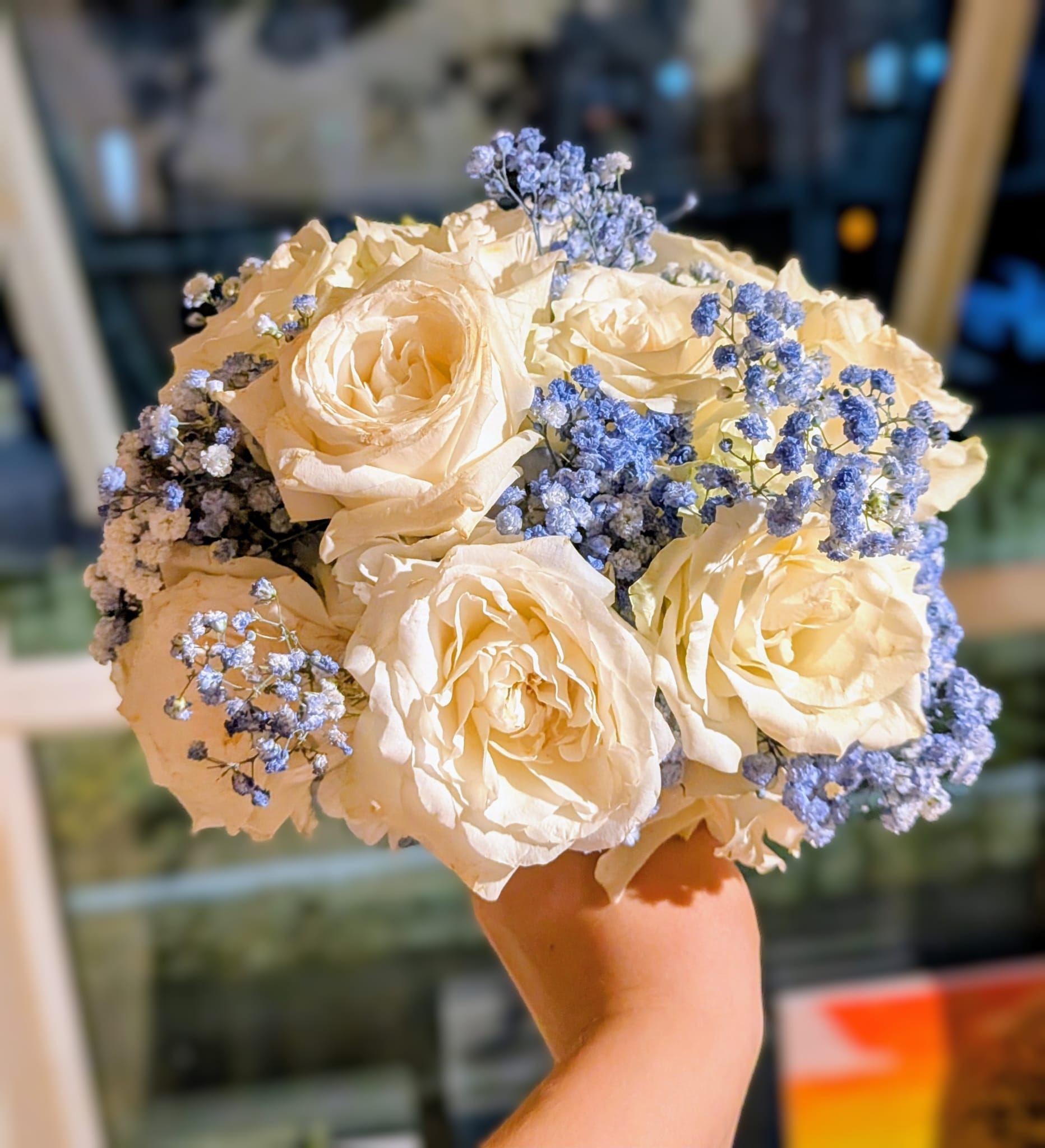 Front view of a blue and white bridal bouquet with trailing ribbon