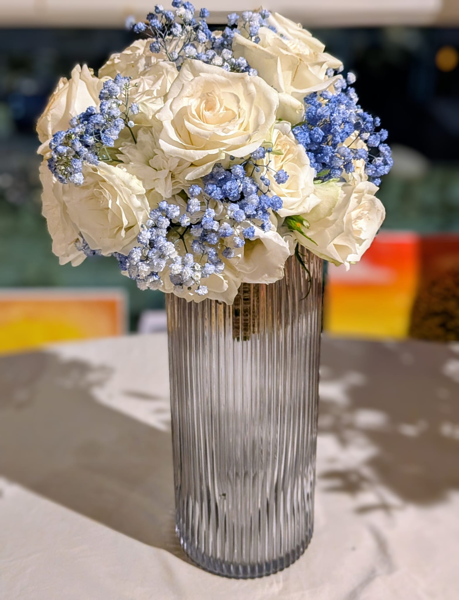 Blue and white bridal bouquet displayed upright to show its shape and ribbon finish