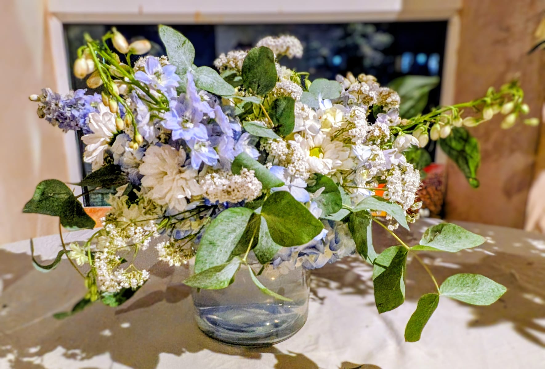 Side view of a blue and white centrepiece styled for a wedding reception table