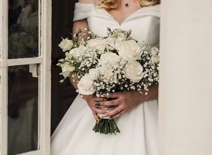 Front-facing bridal bouquet with blush roses and soft trailing greenery