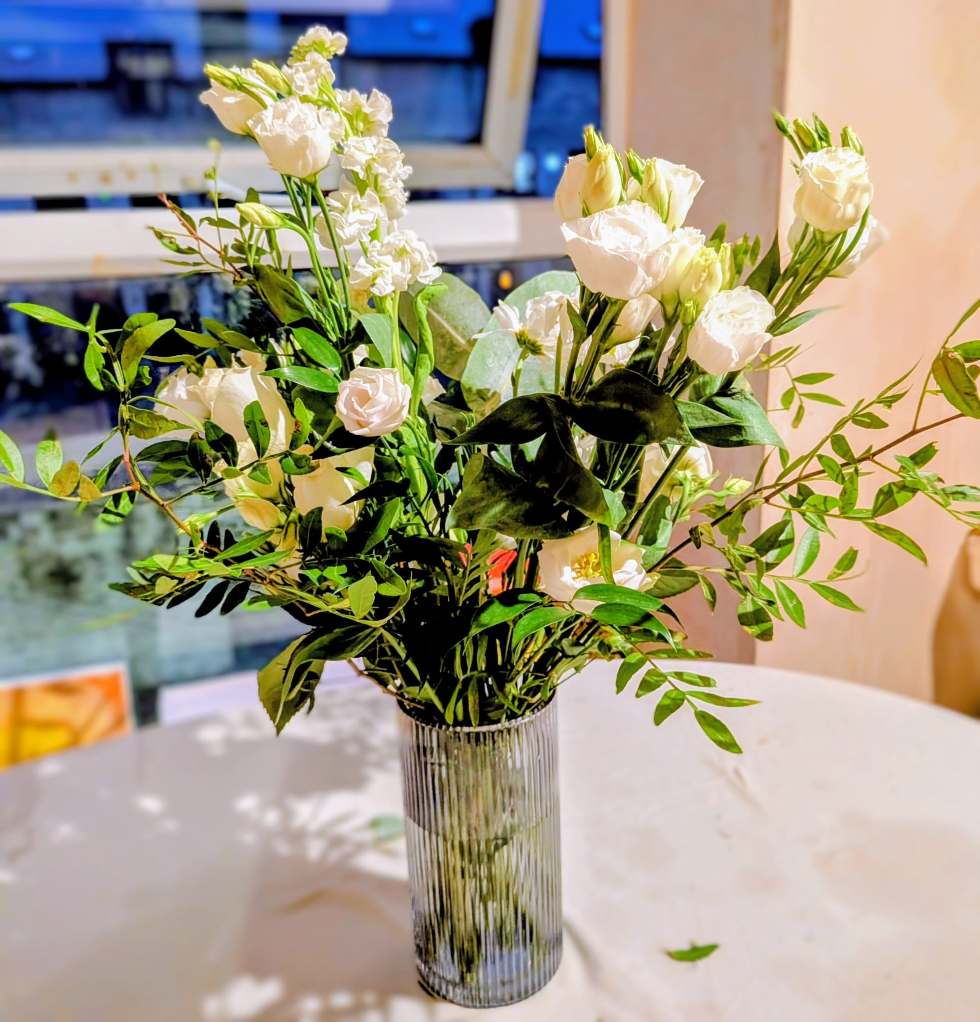 Side angle of a tall white centrepiece showing height and vase styling
