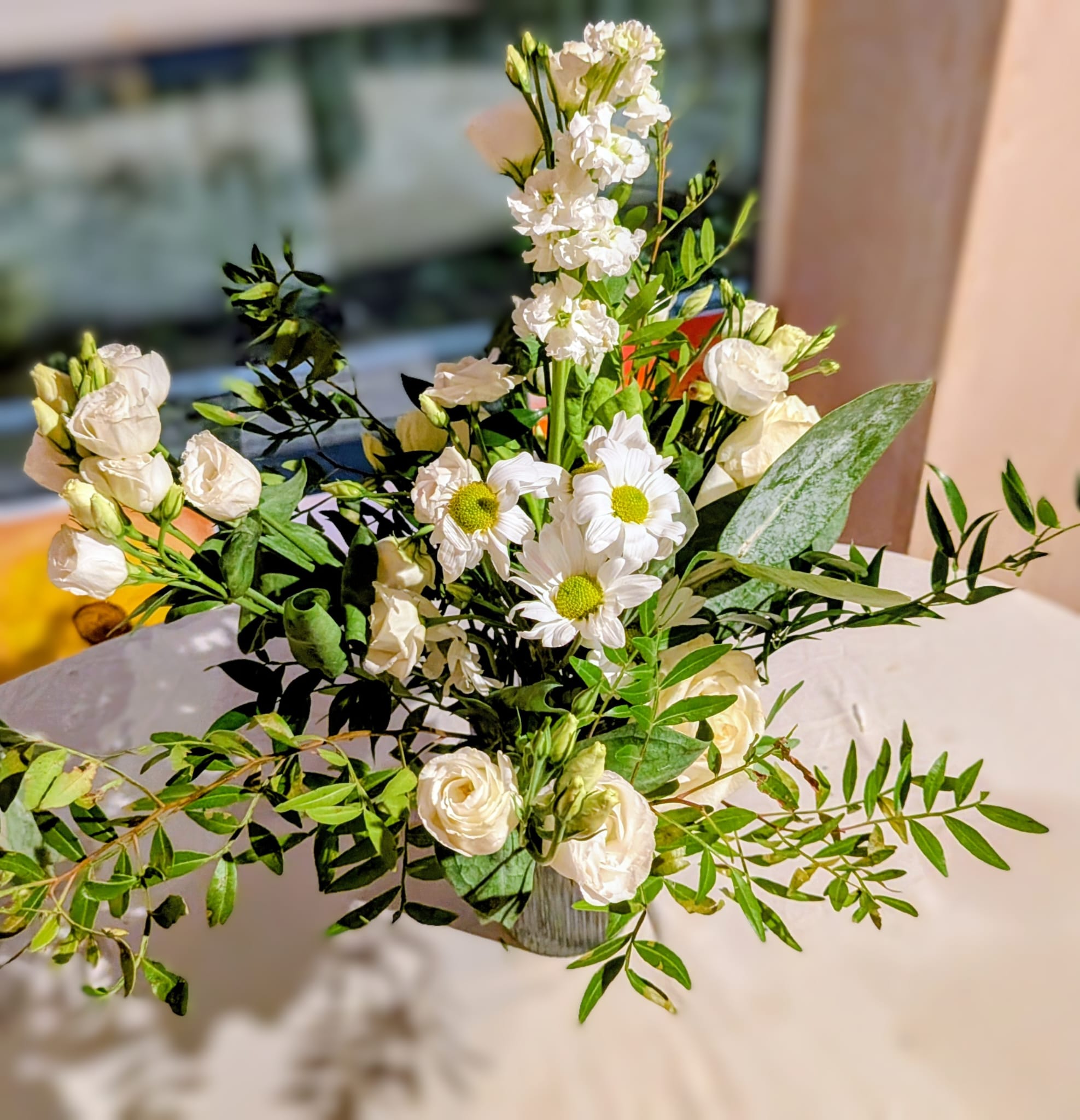 Top view of a tall white centrepiece with layered blooms and candles